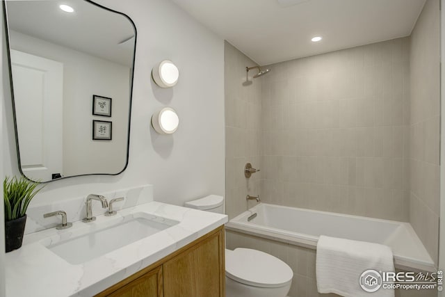 full bathroom featuring tiled shower / bath combo, toilet, and vanity