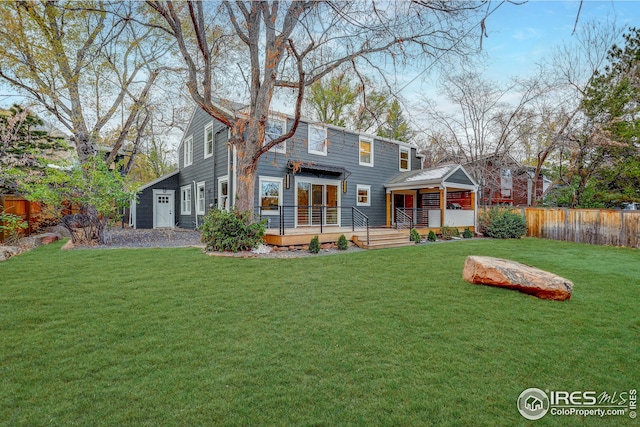 back of house with a wooden deck and a yard