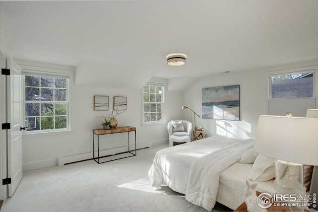 bedroom with light carpet and a baseboard heating unit