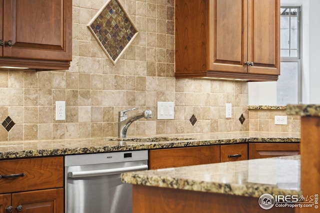 kitchen with tasteful backsplash, light stone counters, dishwasher, and sink