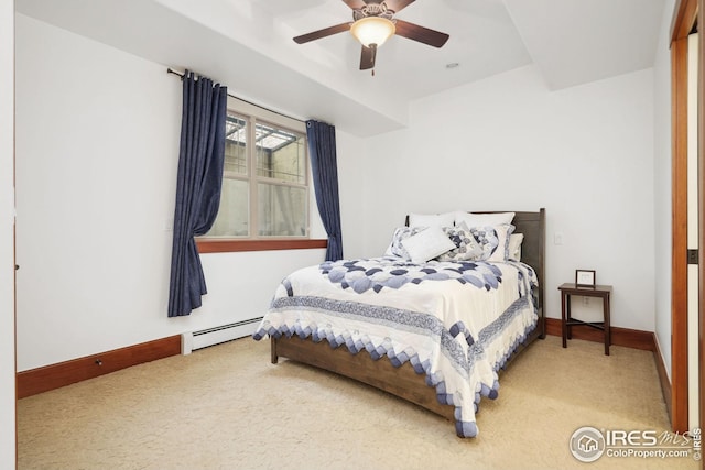 carpeted bedroom featuring ceiling fan and a baseboard heating unit