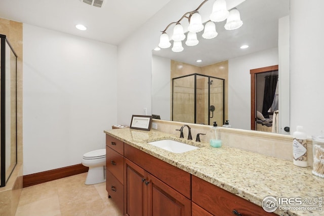 bathroom with tile patterned floors, vanity, a shower with shower door, and toilet