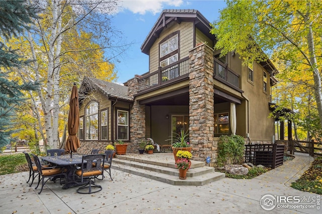 back of property with a balcony and a patio