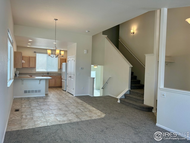 kitchen with a notable chandelier, white fridge, light carpet, a kitchen breakfast bar, and pendant lighting