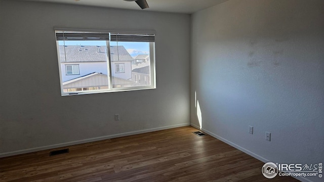 spare room featuring ceiling fan and dark hardwood / wood-style floors