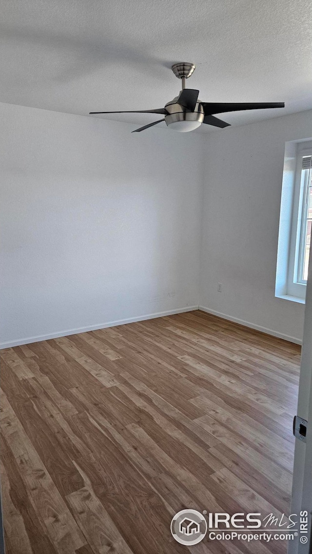 unfurnished room featuring a textured ceiling, hardwood / wood-style flooring, and ceiling fan