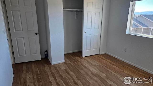 unfurnished bedroom featuring dark hardwood / wood-style floors and a closet