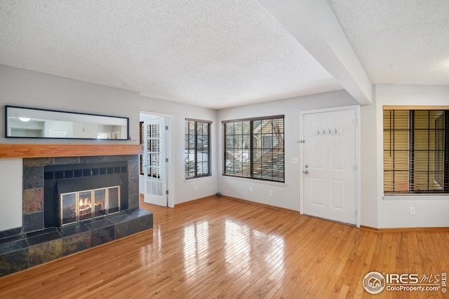 unfurnished living room with a fireplace, hardwood / wood-style floors, and a textured ceiling