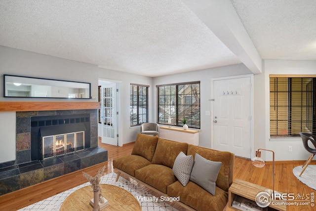 living room with hardwood / wood-style floors, a fireplace, and a textured ceiling