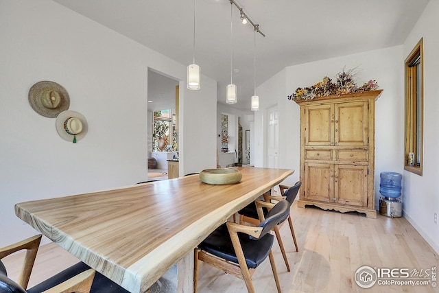 dining area featuring track lighting and light wood finished floors