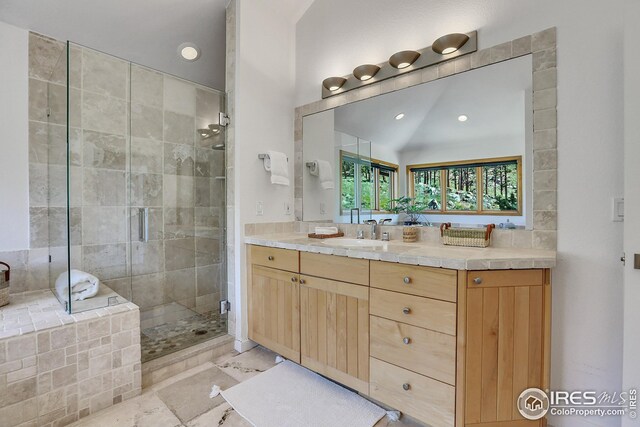 bathroom featuring vanity, lofted ceiling, and a stall shower