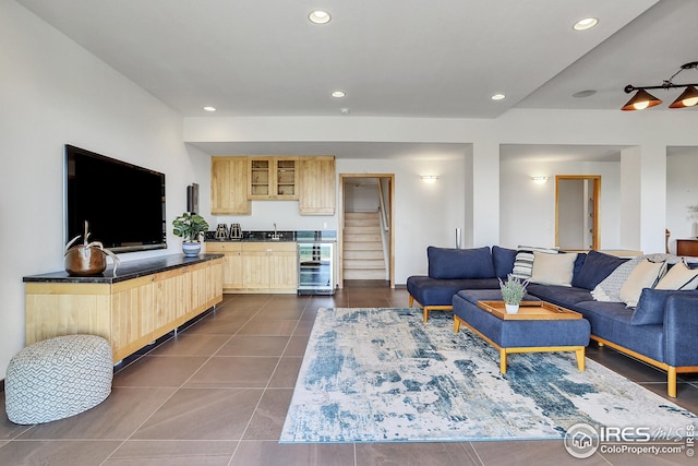 living area featuring recessed lighting, wine cooler, dark tile patterned flooring, and stairs