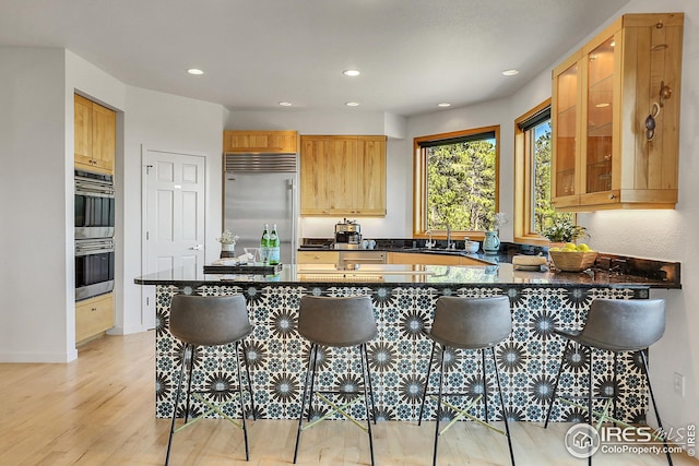 kitchen with recessed lighting, stainless steel appliances, a sink, and light wood finished floors