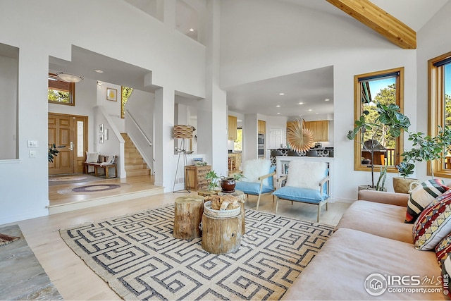 living room featuring recessed lighting, beamed ceiling, a high ceiling, and stairway
