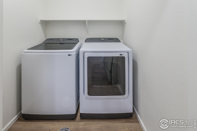 laundry area with dark wood-type flooring and washer and clothes dryer