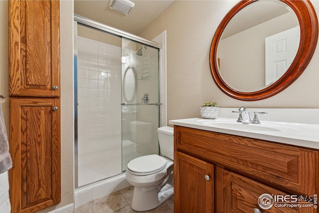 full bath featuring a textured wall, toilet, a stall shower, vanity, and tile patterned flooring