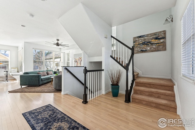 stairs with a ceiling fan, baseboards, and hardwood / wood-style floors