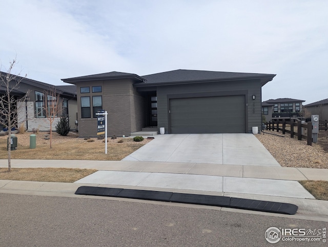 prairie-style house featuring driveway, a garage, and brick siding