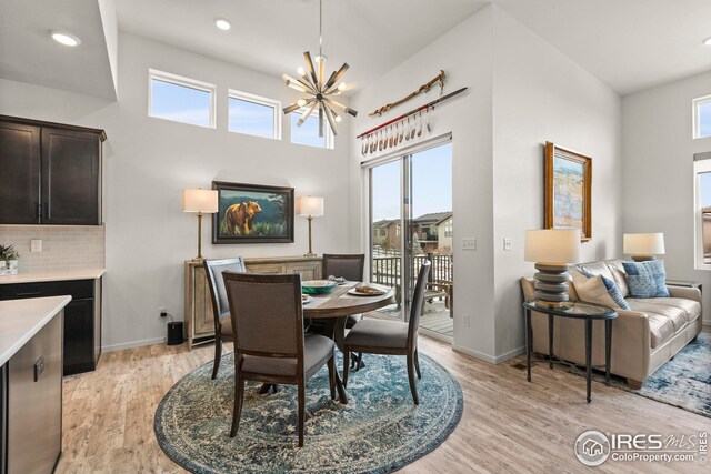 dining space featuring light hardwood / wood-style flooring, an inviting chandelier, and sink