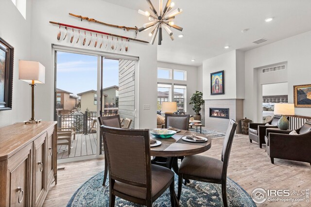 dining space with light hardwood / wood-style flooring and a notable chandelier