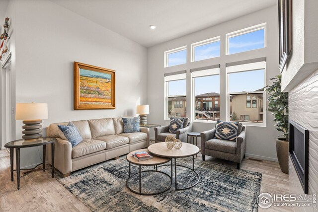 living room featuring light wood-type flooring, sink, and an inviting chandelier