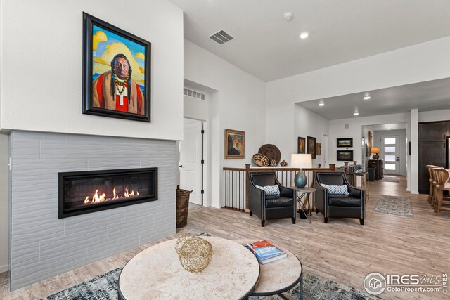 living area featuring a tile fireplace and hardwood / wood-style flooring