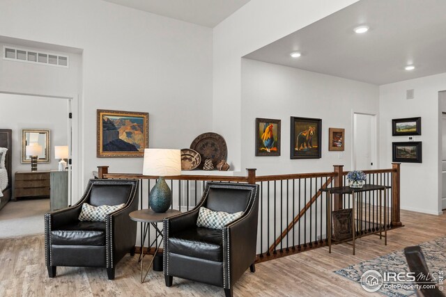 living room with a tile fireplace and light hardwood / wood-style flooring