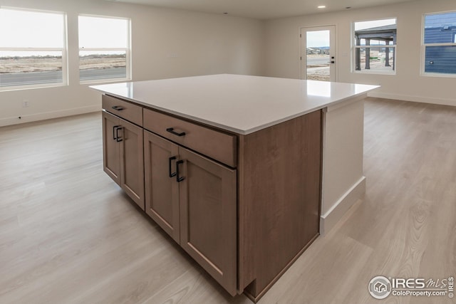 kitchen featuring a kitchen island, plenty of natural light, and light hardwood / wood-style floors