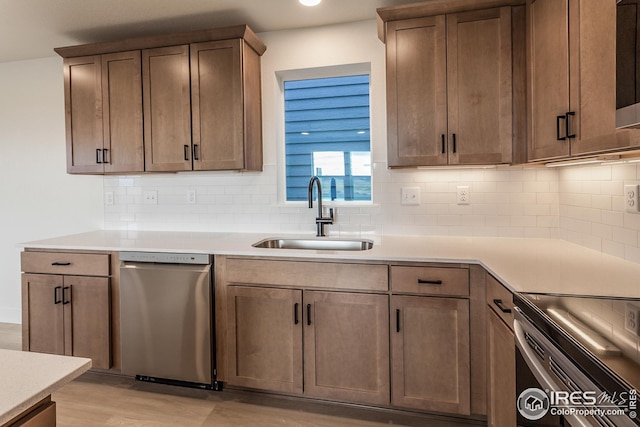 kitchen with sink, light wood-type flooring, dishwasher, and backsplash