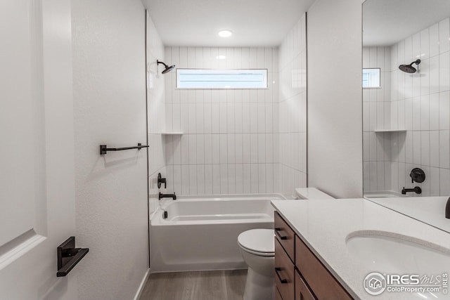 full bathroom featuring toilet, tiled shower / bath, vanity, and hardwood / wood-style floors