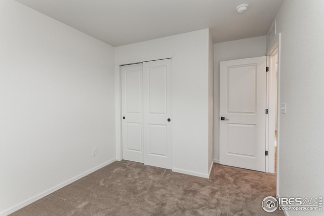 unfurnished bedroom with a closet and carpet flooring