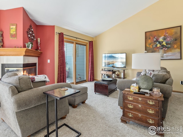 living area featuring carpet flooring, lofted ceiling, and a glass covered fireplace