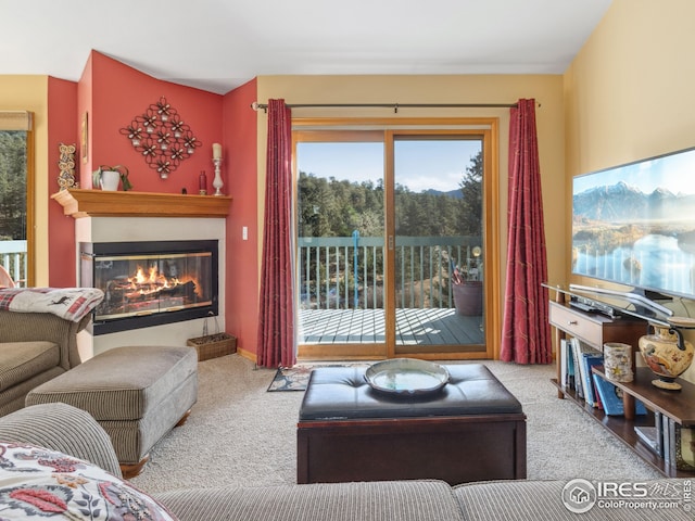 carpeted living room with a glass covered fireplace