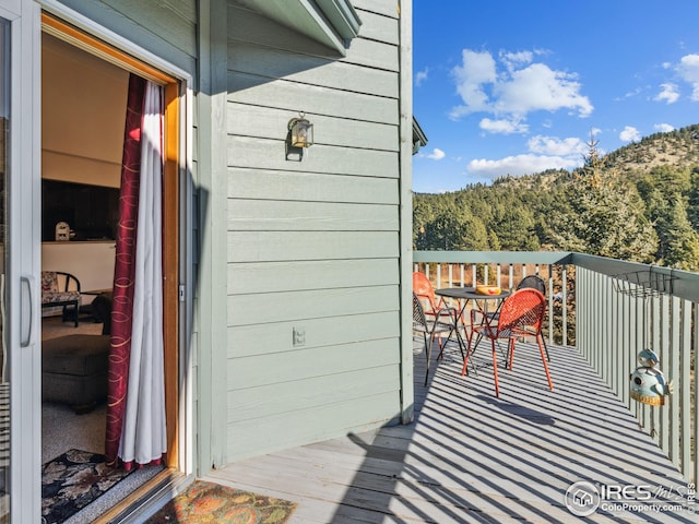 wooden terrace with a wooded view