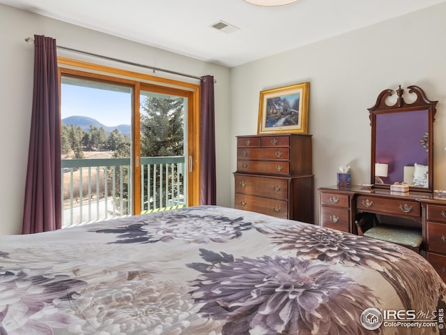 bedroom with visible vents, a mountain view, and access to outside