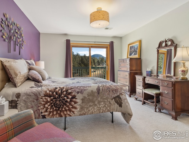 bedroom featuring access to exterior, light colored carpet, and visible vents