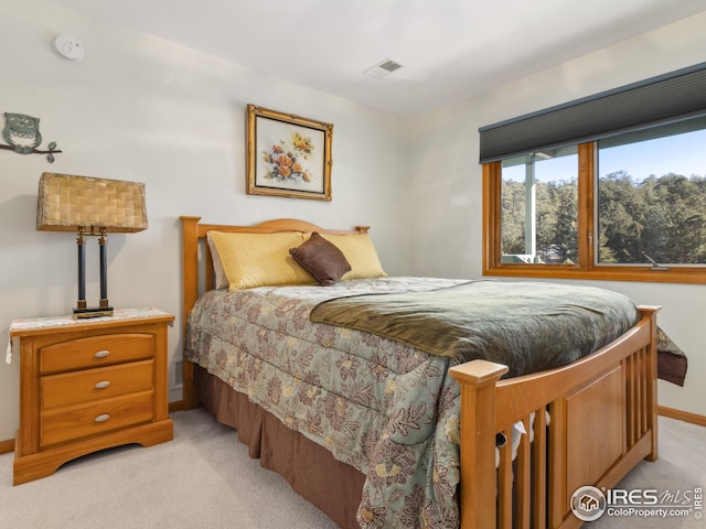 bedroom featuring light colored carpet, visible vents, and baseboards