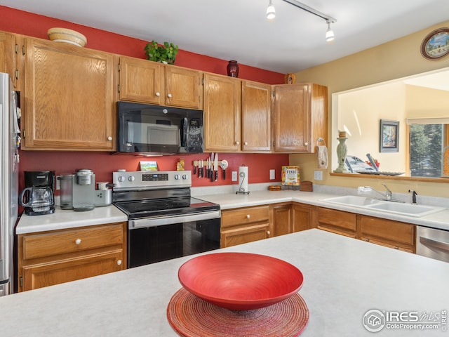 kitchen with appliances with stainless steel finishes, light countertops, and a sink