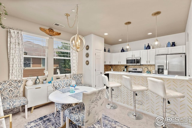 dining area with light carpet, visible vents, a notable chandelier, and recessed lighting