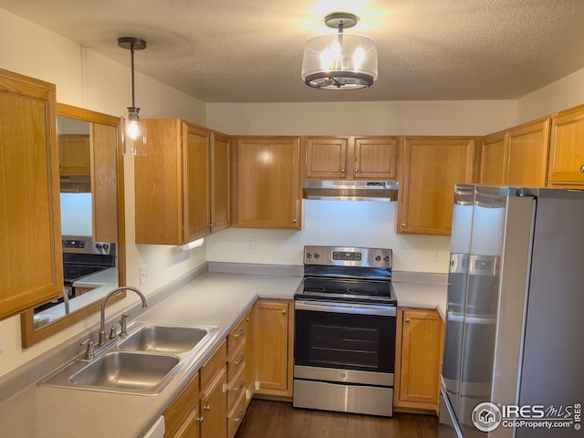 kitchen with stainless steel appliances, sink, hanging light fixtures, and a textured ceiling