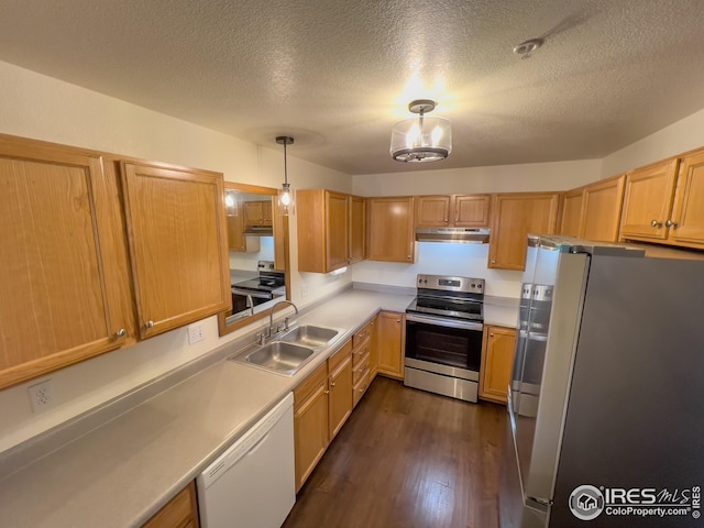 kitchen featuring sink, appliances with stainless steel finishes, hanging light fixtures, dark hardwood / wood-style floors, and a textured ceiling