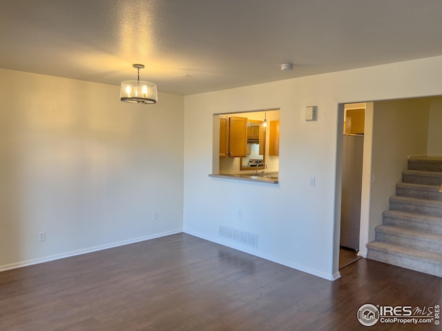 unfurnished living room with dark hardwood / wood-style floors, sink, and a chandelier