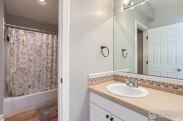 bathroom with shower / tub combo, vanity, wood-type flooring, and tasteful backsplash