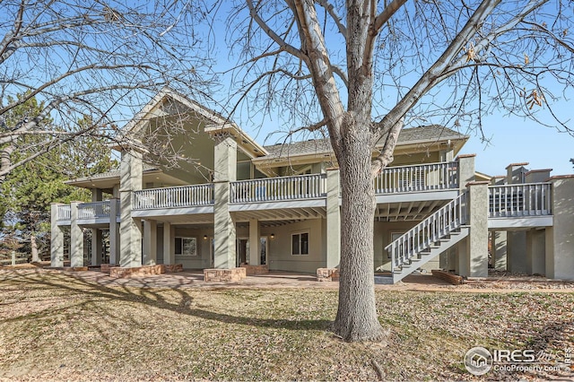 back of property with a yard and a patio