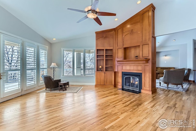 living area featuring light hardwood / wood-style flooring, high vaulted ceiling, and ceiling fan