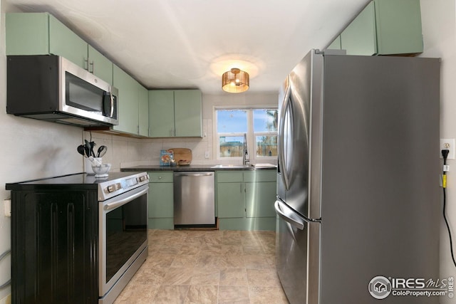 kitchen with appliances with stainless steel finishes and green cabinetry