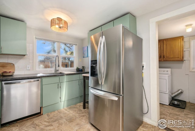 kitchen featuring green cabinets, stainless steel appliances, washer / clothes dryer, and sink