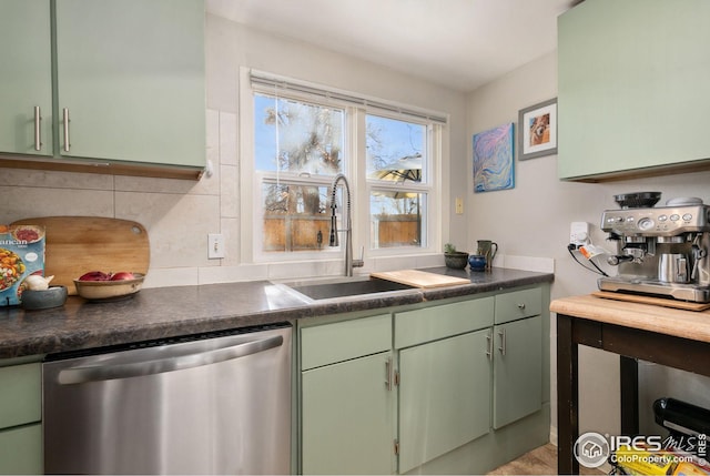 kitchen with stainless steel dishwasher, sink, and green cabinets