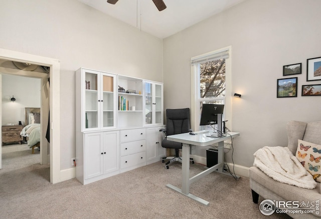 carpeted home office featuring ceiling fan