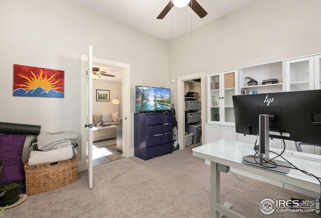 carpeted office featuring ceiling fan, french doors, and a towering ceiling